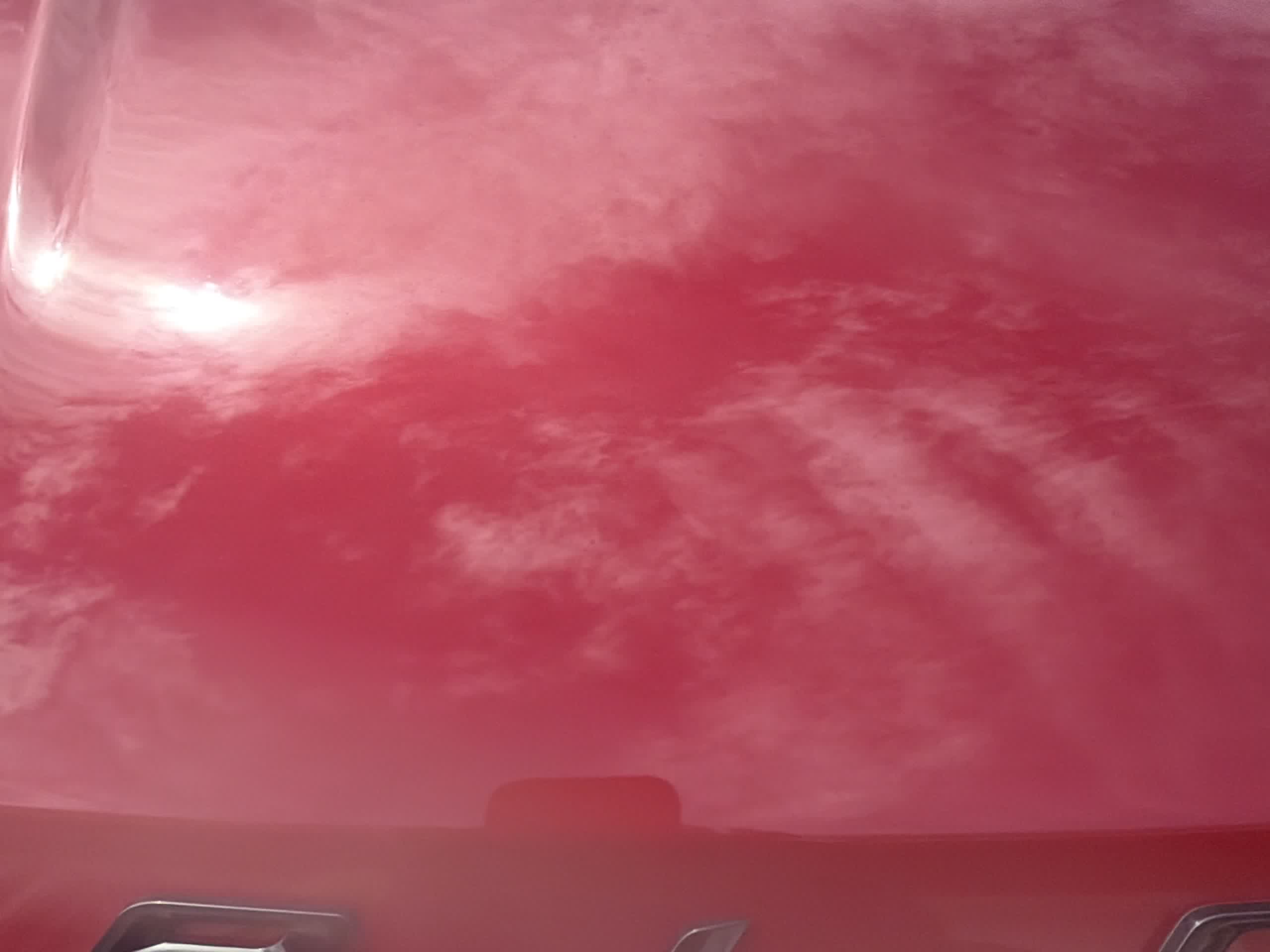 Mirror finish on a ceramic coated hood reflecting the sky
