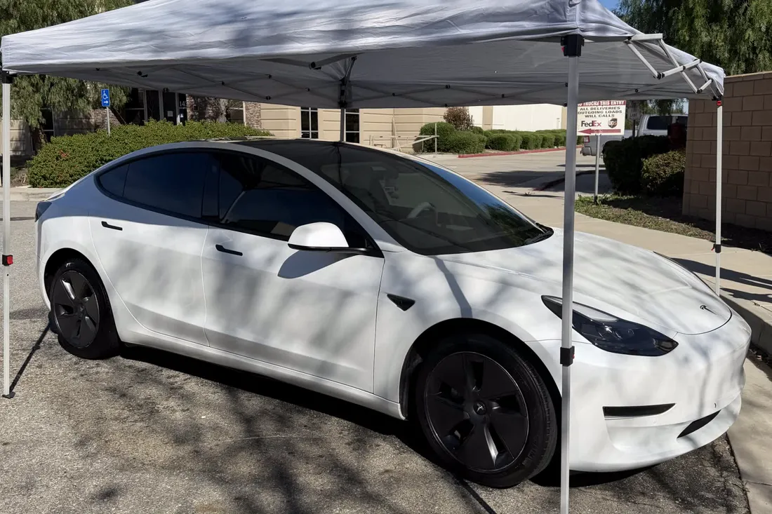 White Tesla Model 3 under a shade canopy after a ceramic coating